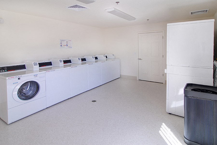 a washer and dryer room in a white room with a door