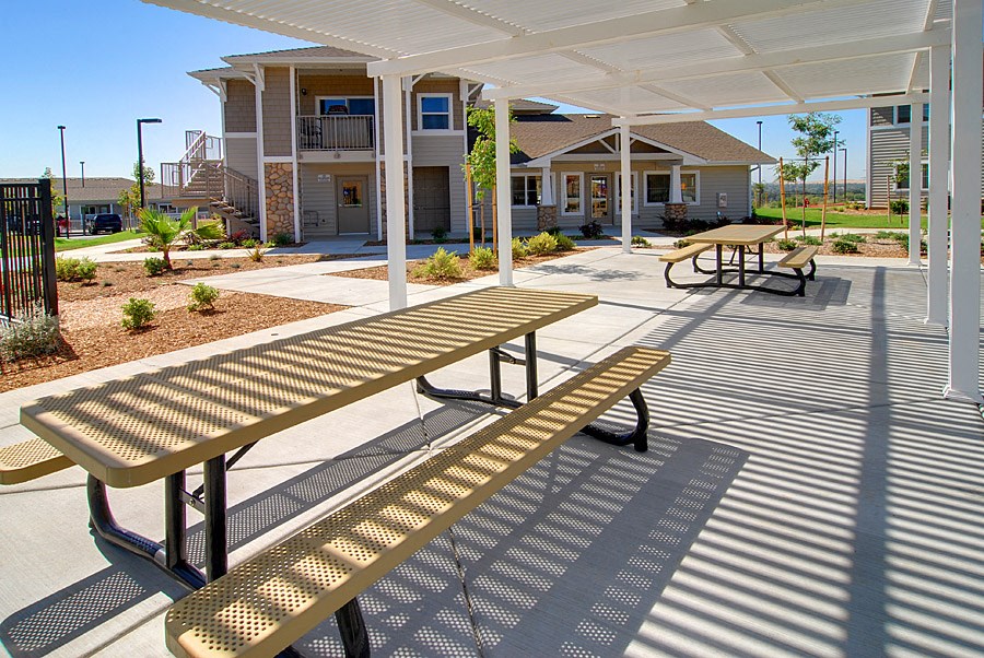 a picnic area with benches in front of a building