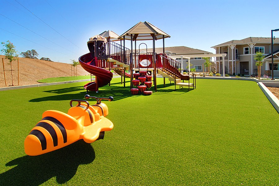 a playground with a swing set in front of a building