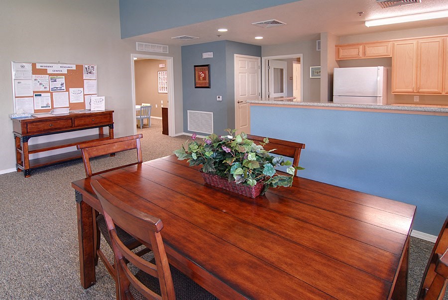 a dining room with a wooden table and a kitchen