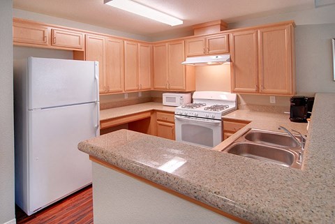 a kitchen with white appliances and granite counter tops