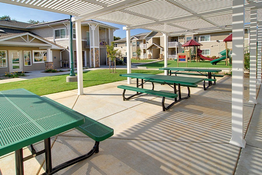 an outdoor picnic area with benches and picnic tables