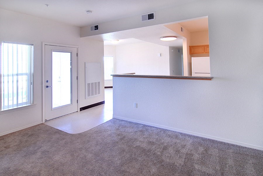 the living room and kitchen of an empty apartment