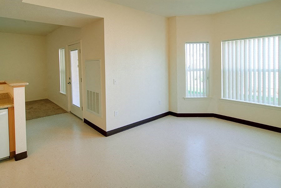 an empty living room with a door and window