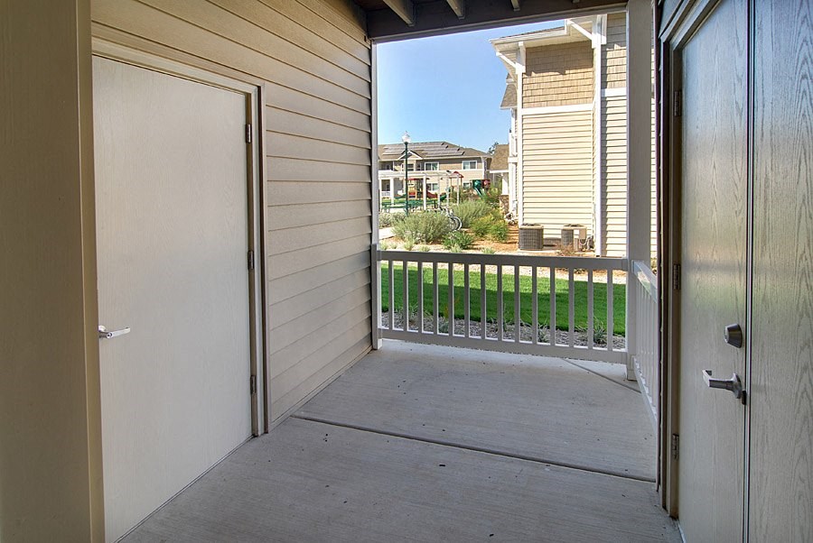 a porch with a door and a view of a house