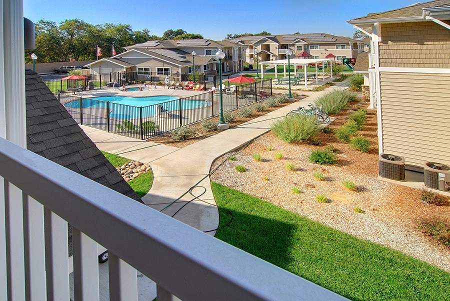 a view of a pool from the balcony of a house