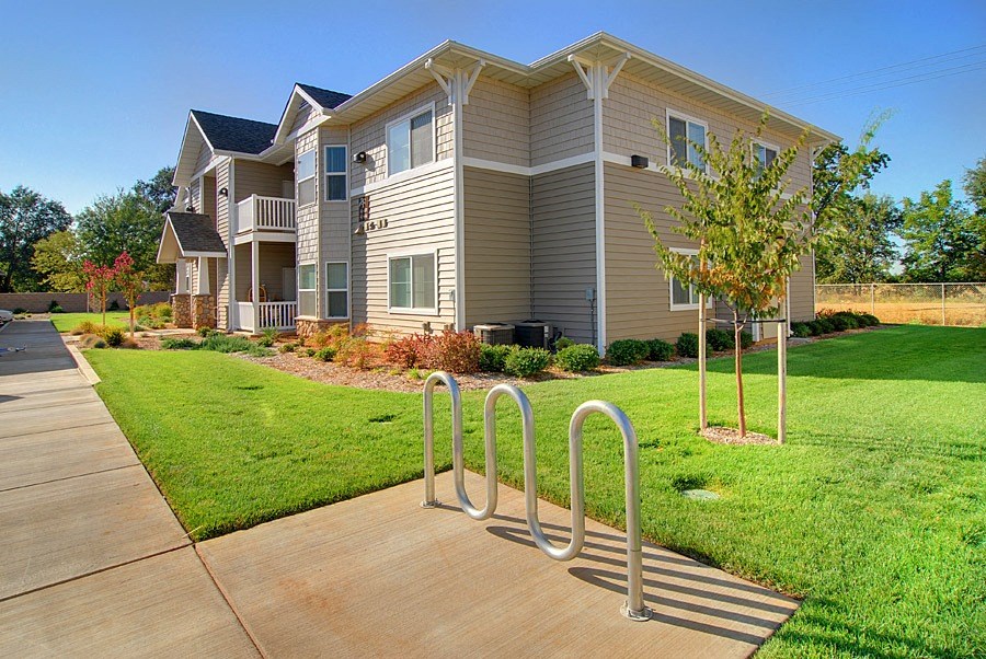 an apartment building with a walkway with bike racks