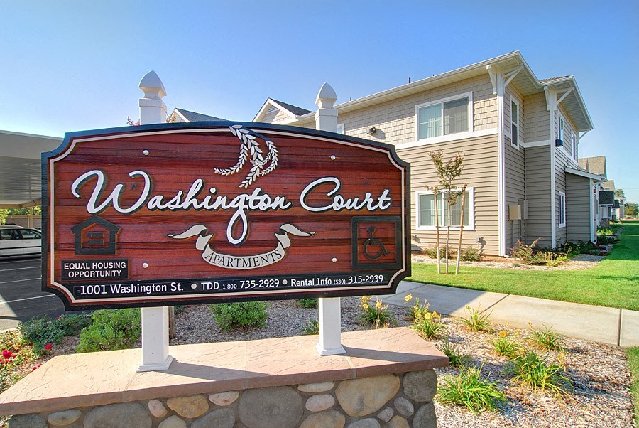 a sign for the coast apartments in front of a house