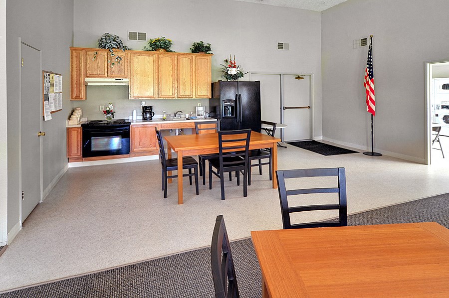 a kitchen and dining room with a wooden table and chairs and an american flag in the