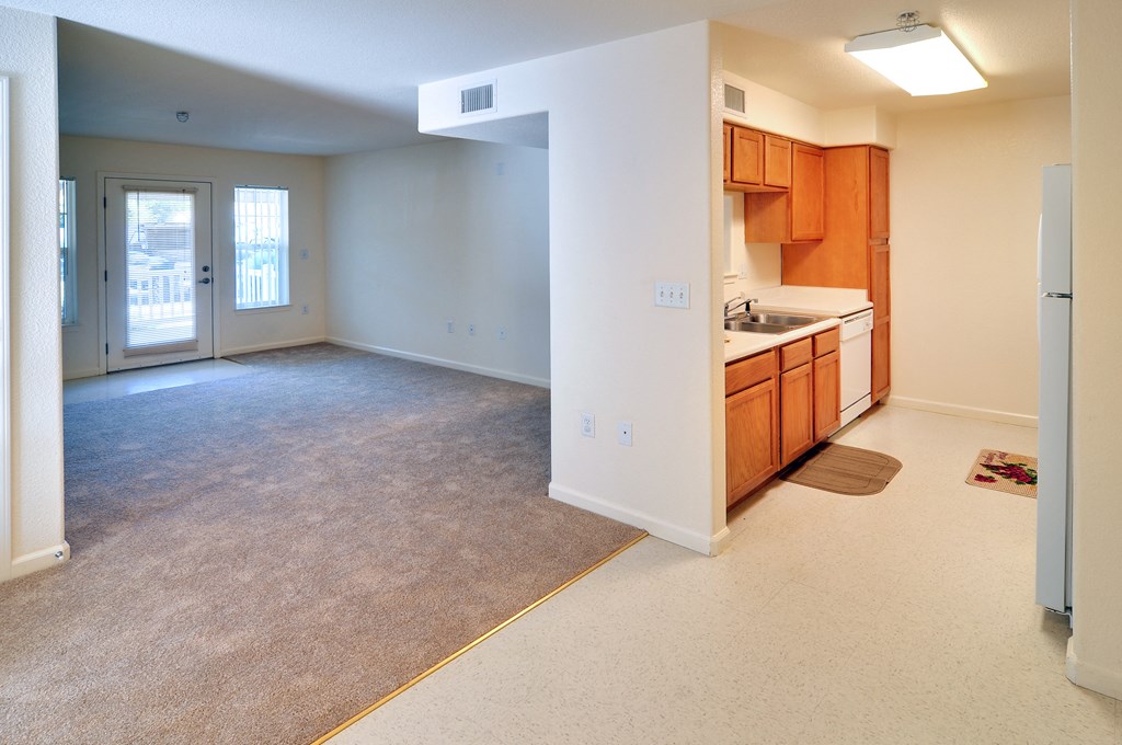a large living room with a kitchen in the background