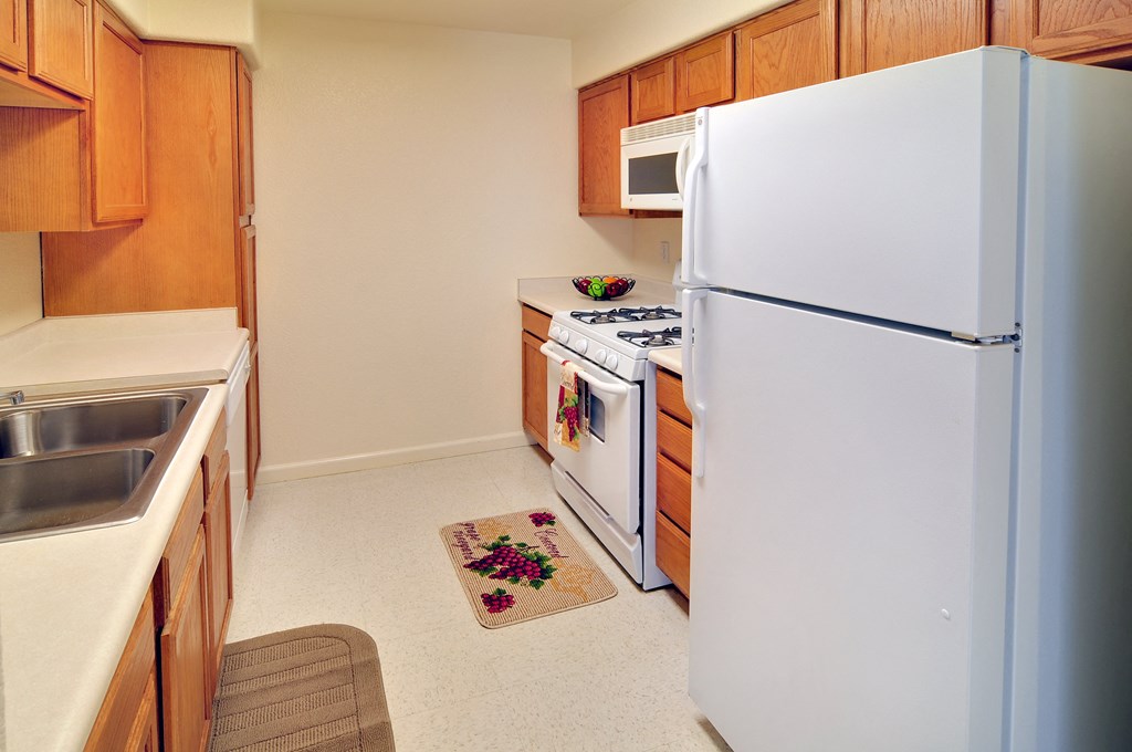 a kitchen with white appliances and wooden cabinets