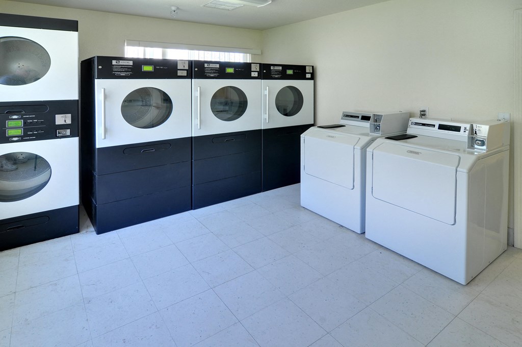 a laundry room with four washers and two dryers