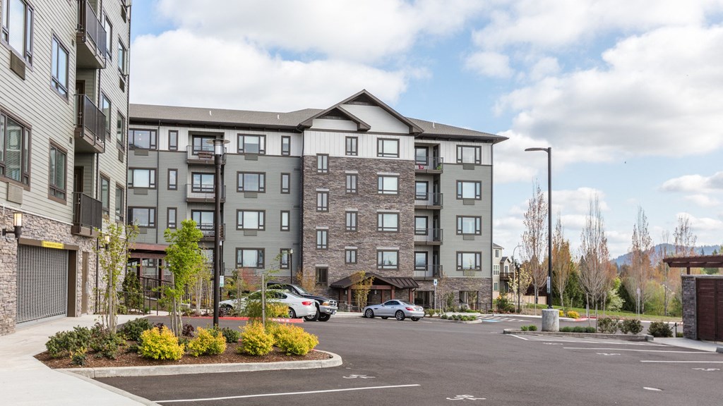 an apartment building in a parking lot with cars