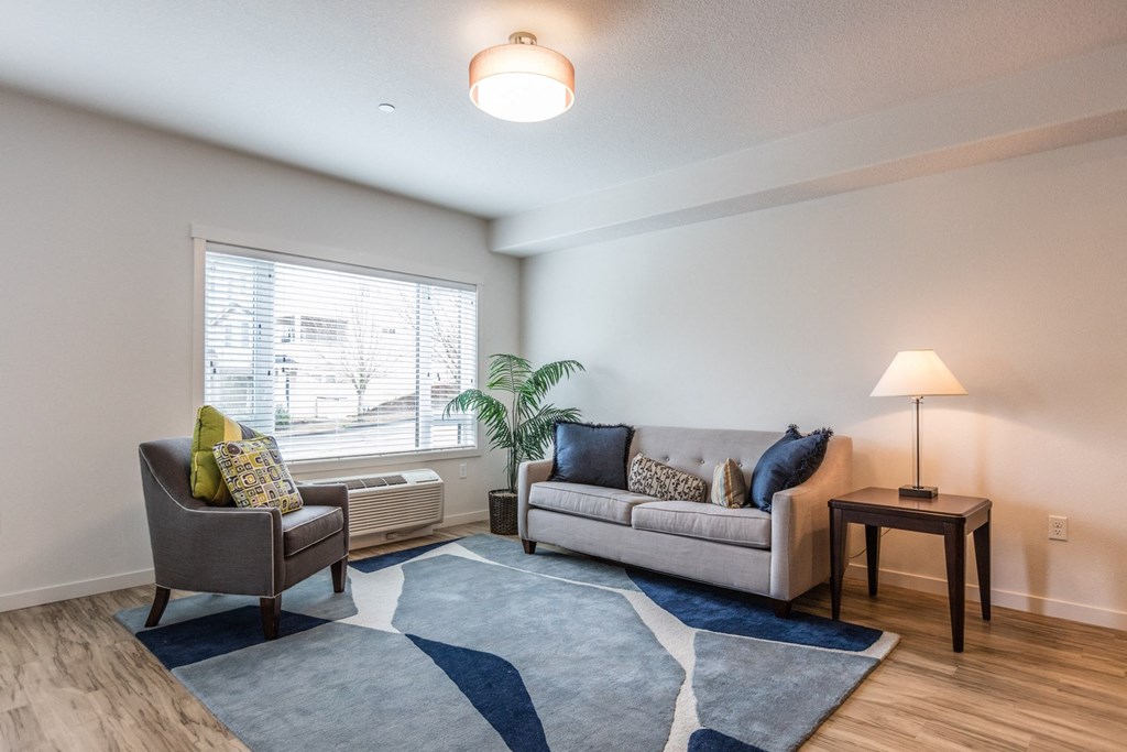a living room with a couch and a chair and a window