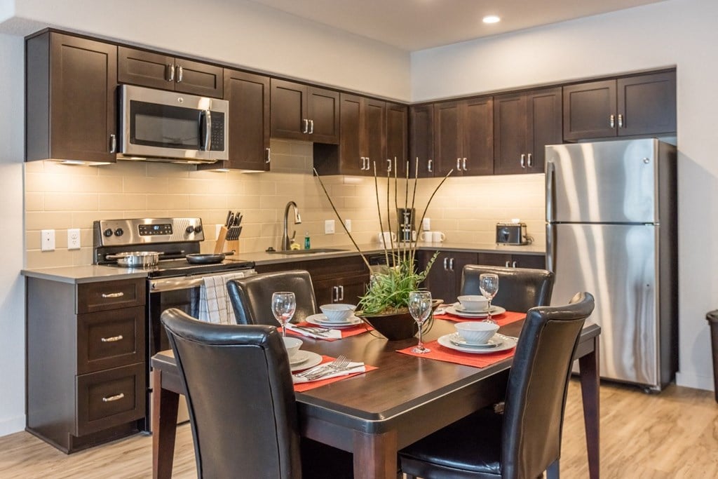 a kitchen and dining room with stainless steel appliances and a wooden table