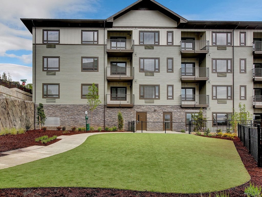 an apartment building with a green lawn in front of it