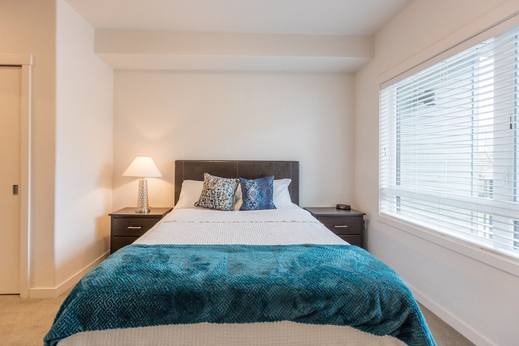 a bedroom with a bed and a large window