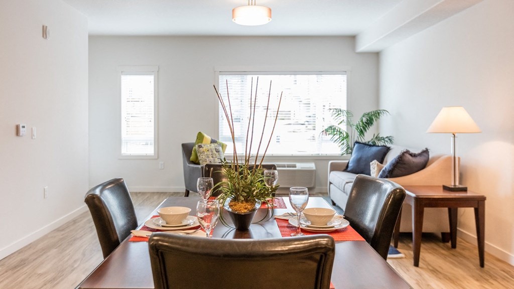 a living room and dining room with a table and chairs