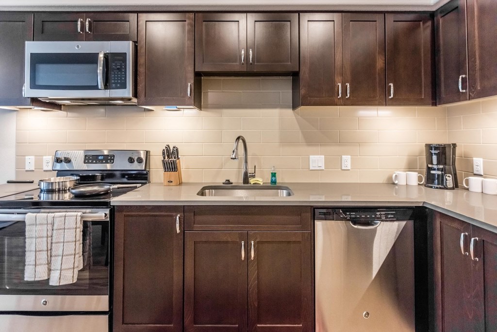 a kitchen with wooden cabinets and a sink and a microwave