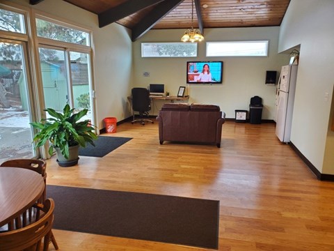 A living room with a brown couch and a television mounted on the wall.