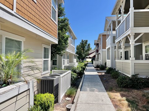 A row of houses with a sidewalk in between.
