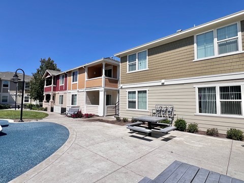 A sunny day at a residential complex with a pool and a picnic table.