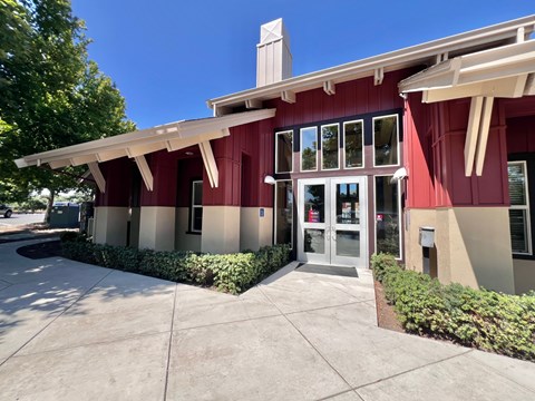 A red building with a white roof and a grey door.