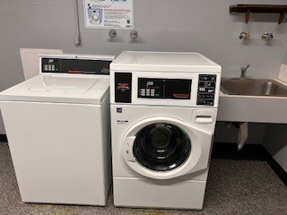 A white washing machine and dryer in a laundry room.