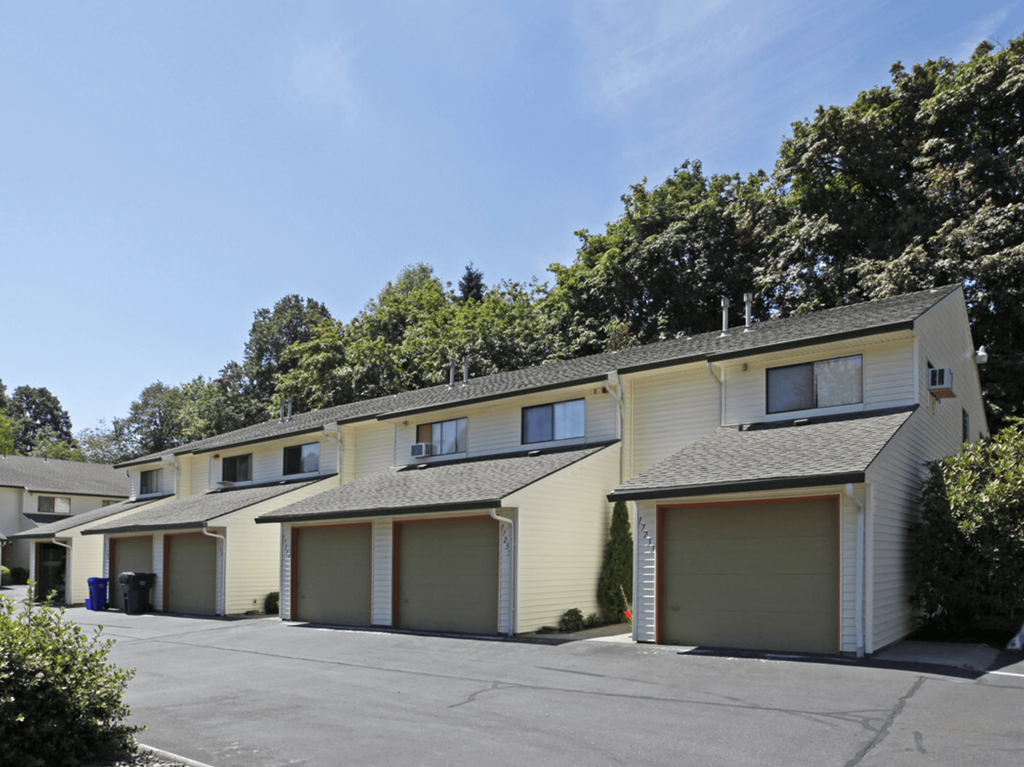 a row of yellow houses with a parking lot