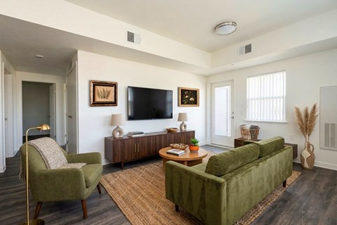 A living room with a green couch, a chair, and a coffee table.