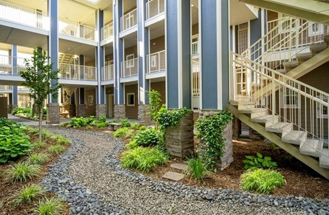 A gravel path leads to a building with a staircase.