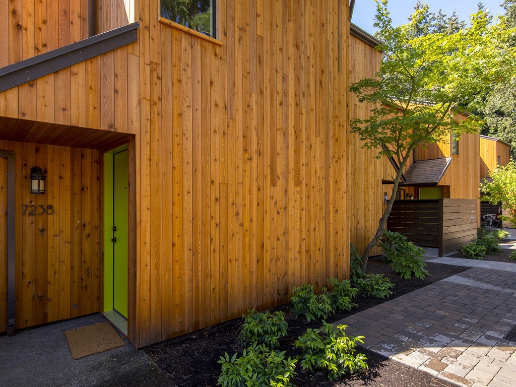 a green door on the side of a wooden house