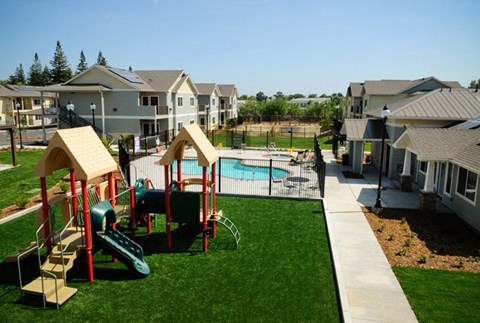 a playground with a pool and houses in the background