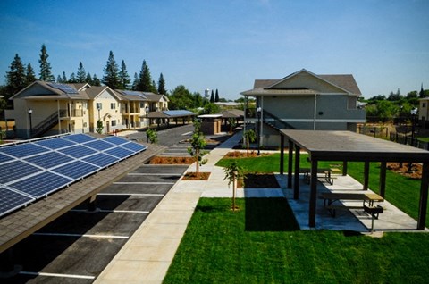 a row of houses with solar panels on the ground