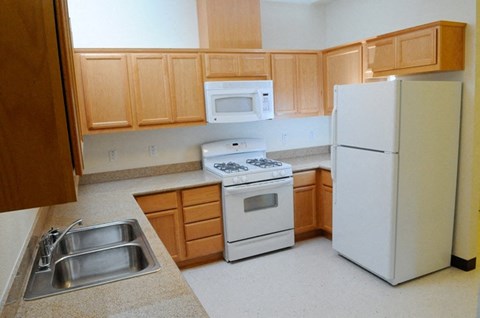 a kitchen with white appliances and wooden cabinets