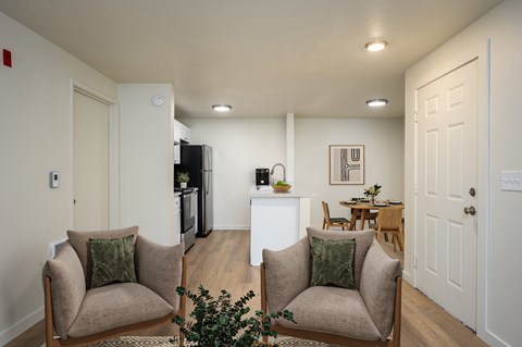 A living room with two chairs and a table in the middle.
