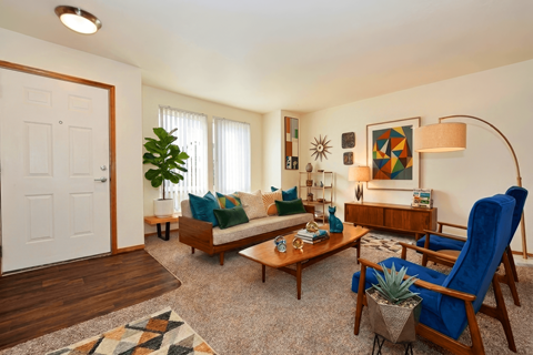 A living room with a blue chair and a wooden bench.