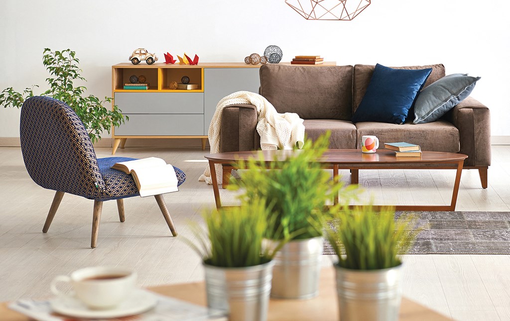a living room with a brown couch and a coffee table with plants