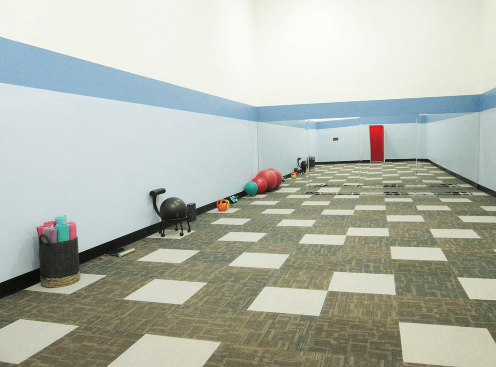 a large room with a checkerboard pattern on the floor and a red door in the