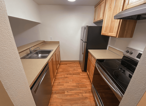 A kitchen with wooden cabinets and black appliances.