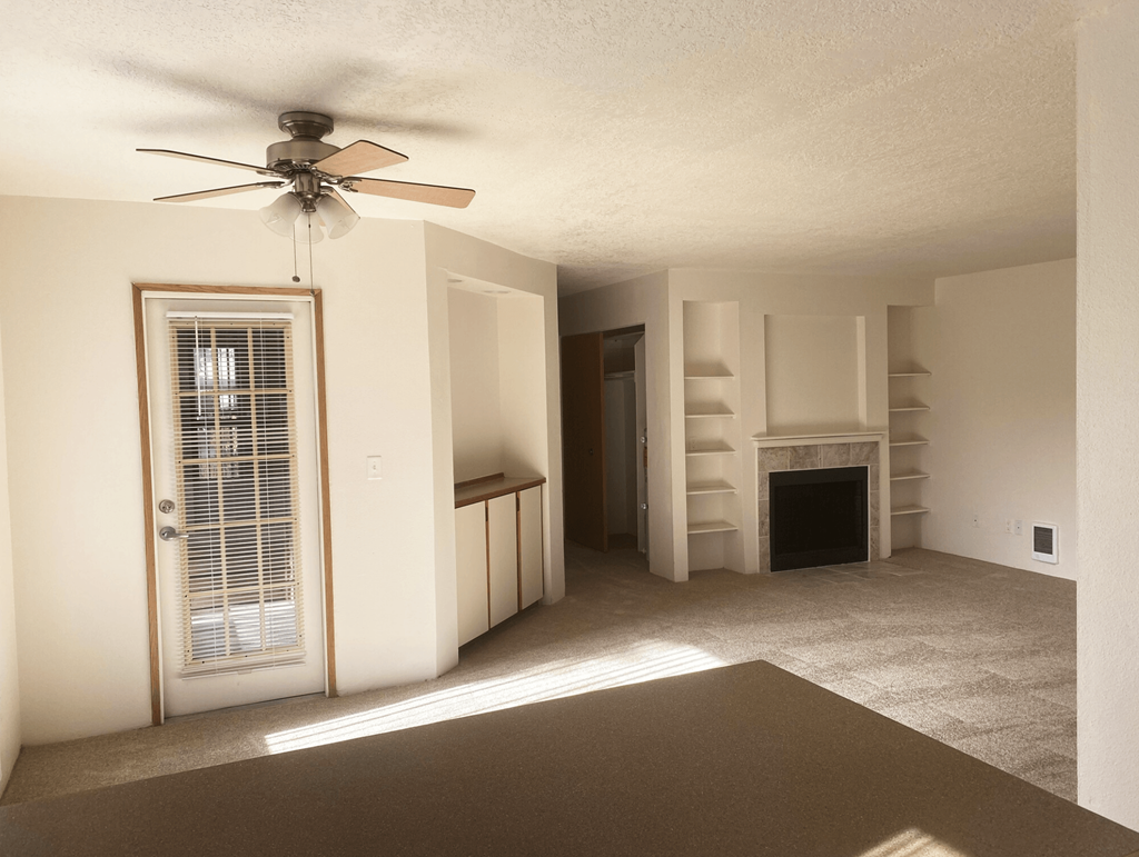 a living room with a fireplace and a ceiling fan