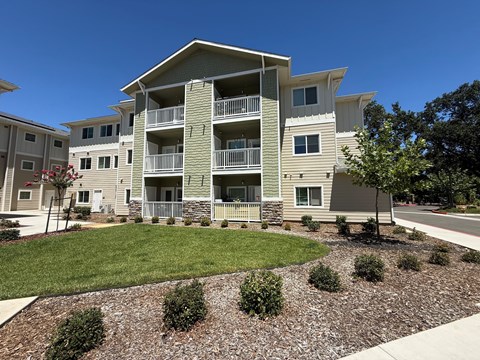 Apartment complex with a green lawn in front.