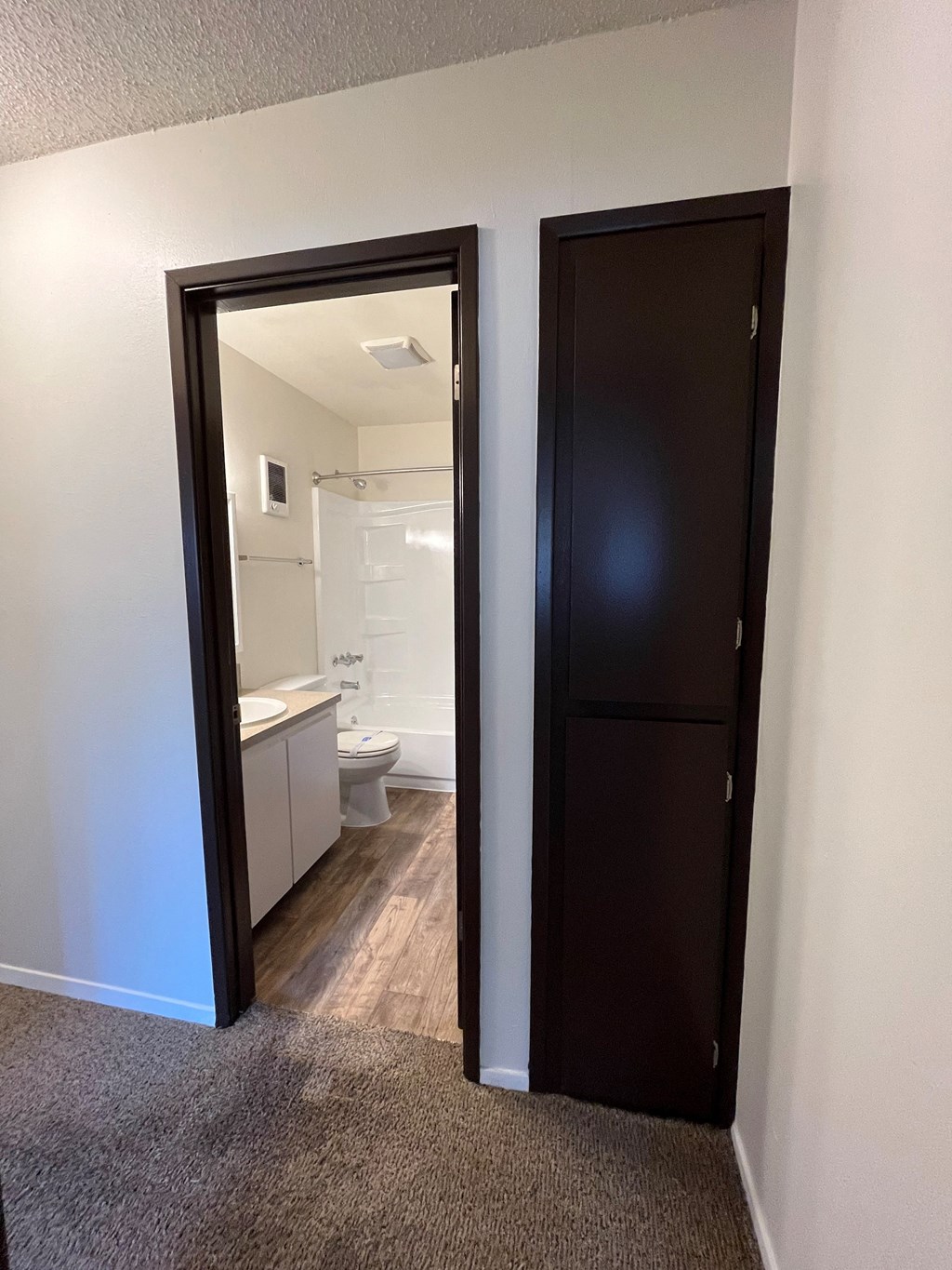 an open door leading into a bathroom with a toilet and sink