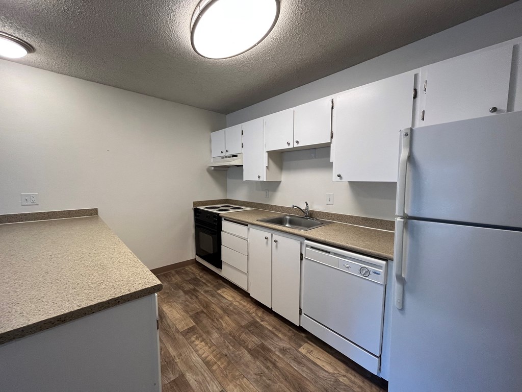 a kitchen with white cabinets and white appliances