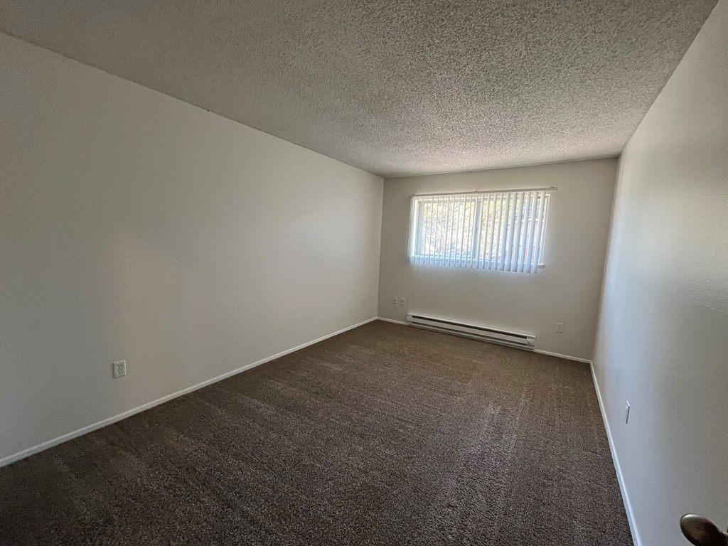 an empty bedroom with a window