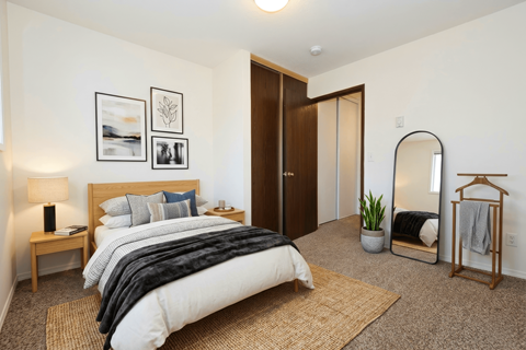 A bedroom with a large bed and a mirror on the wall.