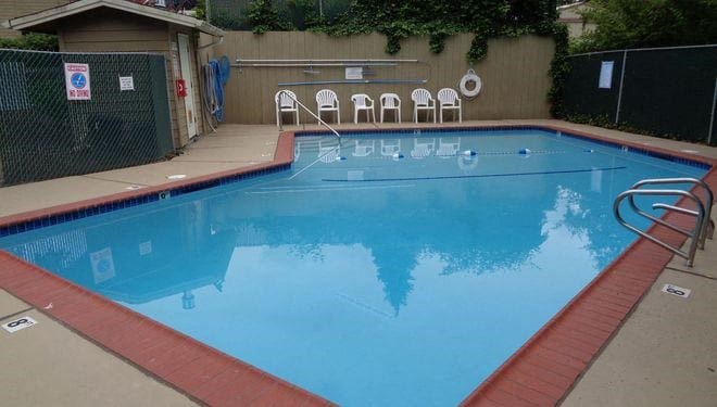 a large blue pool with chairs around it