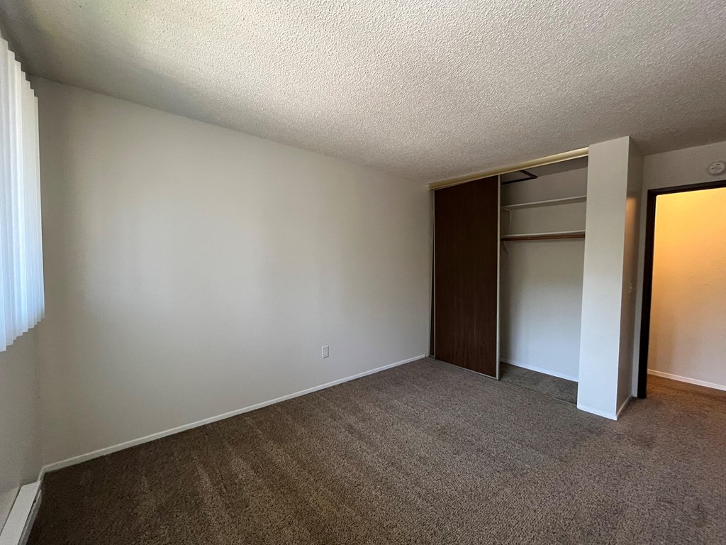 an empty bedroom with a closet