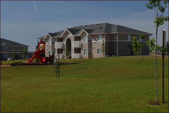 an apartment building with a playground in front of it