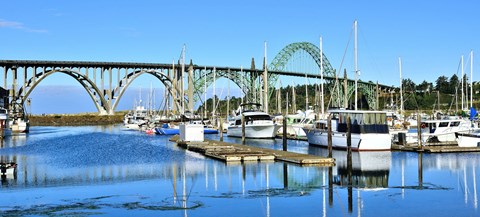 A bridge over a marina with boats docked.